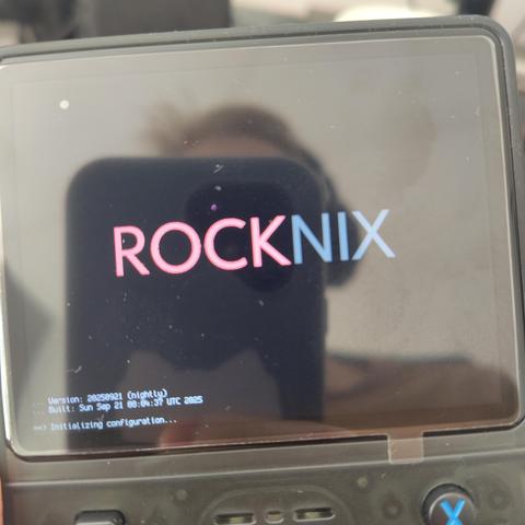 A photo of a retro console with splash screen saying ROCKNIX