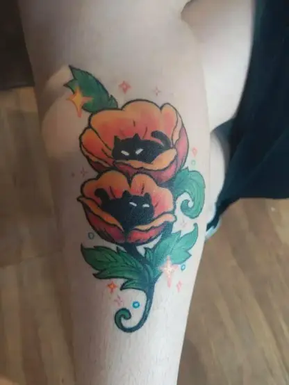 Photo of a clients leg with a healed tattoo of poppy kitties
