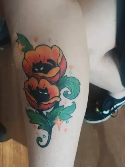 Photo of a clients leg with a healed tattoo of poppy kitties