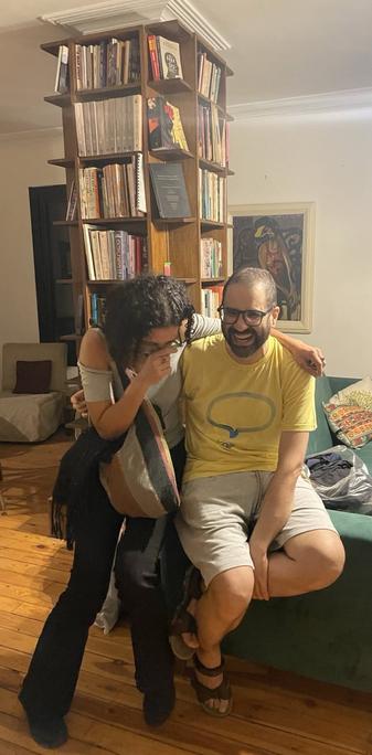 Smiling Alaa seated with his arm around his sister Sanaa