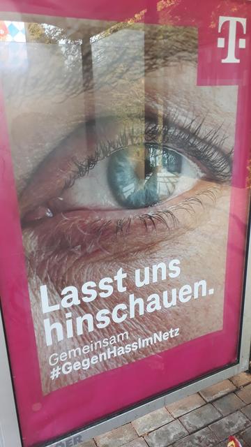 Plakat der Telekom gegen Hass im Netz, mit einem Auge und dem Text
"Lasst und gemeinsam hinschauen. Gemeinsam #gegenHassimNetz
