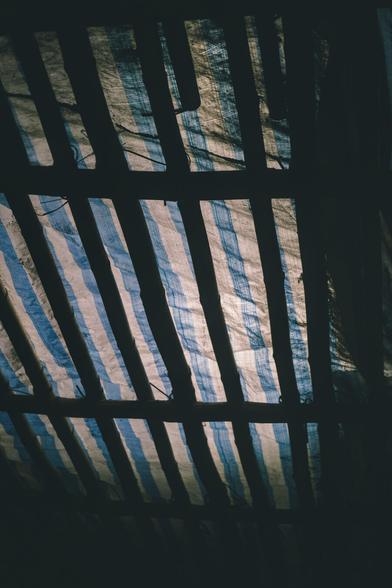 blue and white tarpaulin on a bamboo scaffolding