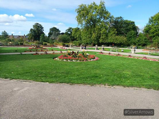 The garden outside the gallery. There's a lawn with a round flower bed in the middle, with mostly red flowers