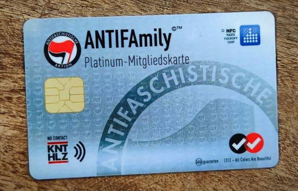 AntiFamily Klubkarte Plastikkarte mit dem Schriftzug 'ANTIFAmily Platinum-Mitgliedskarte', Antifaschistische Aktion Logo mit zwei roten und schwarzen Fahnen, NFC-Chip und weiteren Symbolen.