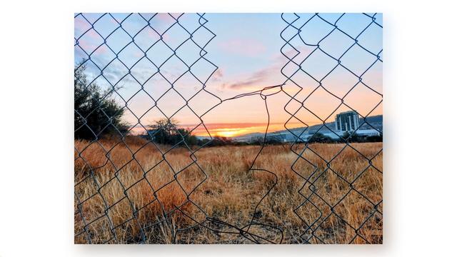 Sunset through a broken fence