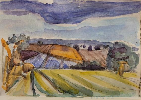 Aquarellskizze im kleinen Skizzenbuch: leicht wellige Landschaft mit bunten Feldern, am Himmel eine große blaugraue Wolke