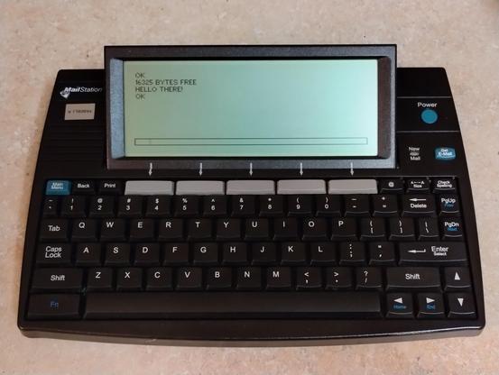 Cidco Mailstation (boxy black device with keyboard and built in angled lcd screen).  The screen reads,
OK
16325 BYTES FREE
HELLO THERE!
OK