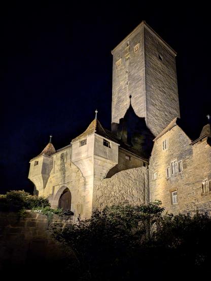 Nachtaufnahme des mächtigen Turms und Stadttores von Rothenburg ob der Tauber, dramatisch von unten angestrahlt. Foto by Johann Seidl, Gartenpoet.