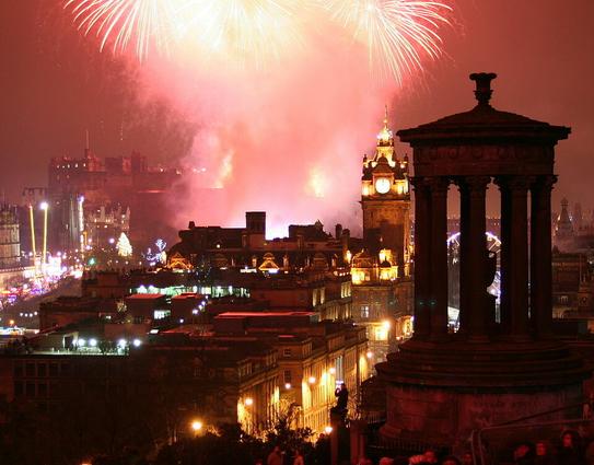 Fireworks over Edinburgh, 1 January 2011; fireworks exploding over a cityscape featuring a clock tower