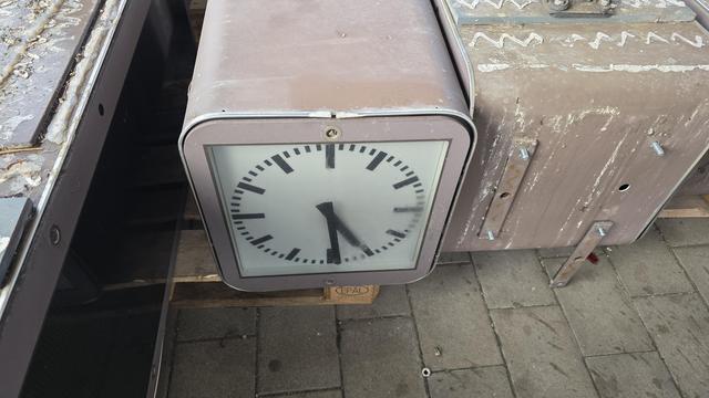 Es ist eine abmontierte analoge Uhr, die früher neben Fahrtanzeigetafeln der Hochbahn/hvv in Hamburg hingen, auf einer Palette zu sehen.