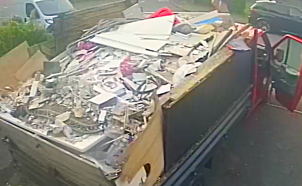 A red pickup truck filled with rubble, timber and other building materials, photographed by Neath Port Talbot Council as part of a fly‑tipping investigation