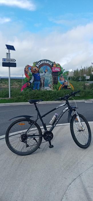 Mon vélo devant la pancarte de Bienvenue au PAL