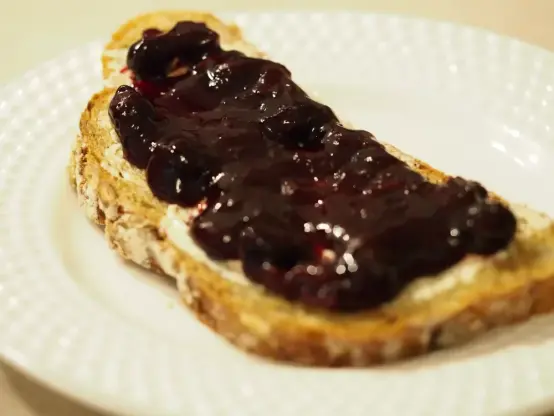 Die Marmelade hat einen sehr dunkel violett-roten Farbton, was sich zeigt, wenn man sie auf ein Brot streicht.