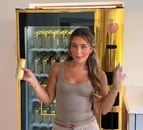 Screenshot of a banned TikTok advert where Love Island’s Lucinda Strafford received a gold AU Vodka vending machine stocked with Juicy Peach flavour, ruled in breach of alcohol advertising rules by the ASA.
