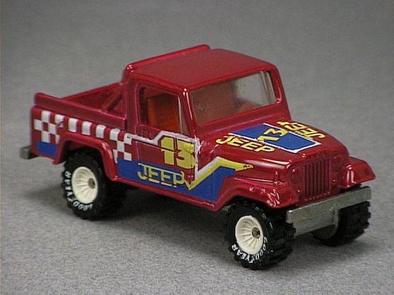 Released in 1985, Plum Jeep Scrambler of 1985 Hot Wheels with Real Riders wheels. Notes: black roof with red truck bed. Tampo: White, yellow and blue striping with '13' and 'Jeep' on sides, '13' and 'Jeep' twice on hood. Packaging: 1985 Blister. Metal Body, Metal Base. Made in Malaysia. Scarcity: 4/10