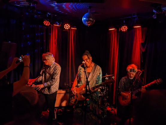 A photo of FaithNYC performing at Berlin in New York City. The band features bassist and vocalist Felice Rosser, with keyboards, guitar and drums.
