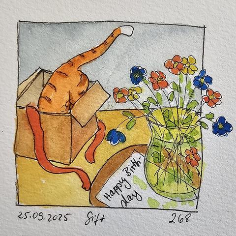 Auf einem runden Tisch steht eine gelbe Glasvase mit einem Blümchenstrauß. Dahinter sieht man eine rotgetigerte Katze, die gerade in den Karton gesprungen ist. 

A yellow glass vase with a bouquet of flowers stands on a round table. Behind it, you can see a red tabby cat that has just jumped into the box.