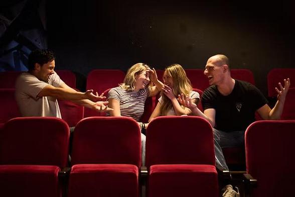 Vier Schauspieler in den Zuschauersesseln