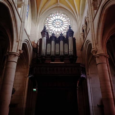 an organ under a round lead-glass window