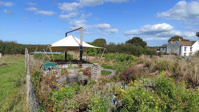 New garden with canvas shelter supported between 2 telegraph poles