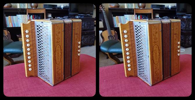 A Hohner folk accordion made of light colored wood. Four buttons on the right are for chords; ten on the left for melody.