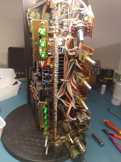 A Technics SU-8080 sitting on it's side, cables an PCBs and potentiometers and switches everywhere. Not a single connection is plugged.