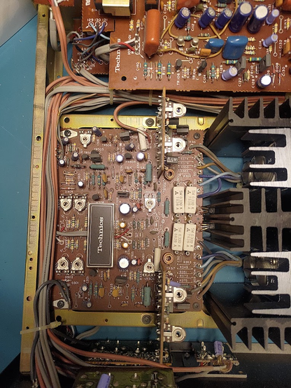 A Technics SU-8080 main PCB, everything is dirty and dusty. One voltage regulator is missing a corner, though it's easy to miss.