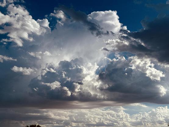 Do you know what this reminds me of? The paintings of Aivazovsky. He was a marine painter. This means that most of his paintings had the sea as the key subject of his work. And what often creates an artistic landscape at sea besides ships? Clouds. 
But those are not just white puffs against a blue background. They have their own volume, play of light and shadow, and composition of various details. Like elements of an urban landscape where different architectures and styles play together.
But other than that here we have a mix of bright white and dark grey clouds against a deep blue background. Light shines through some clouds, creating a lovely contrast.
