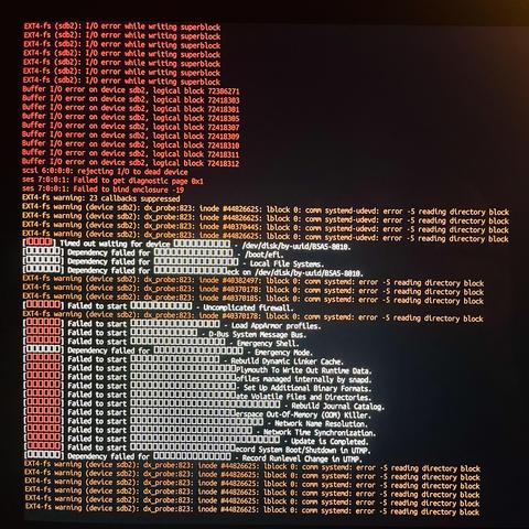 A Linux (unix based) terminal screen clogged with scary red, orange and white boot-up failure notices, none of which is particularly comprehensible, but all of which are clearly the result of many, many clever people working decade-upon-decade to make electrons do clever things like breathing at least enough minimal life into hardware so as to present error messages akin to the shouts of a drowning man.