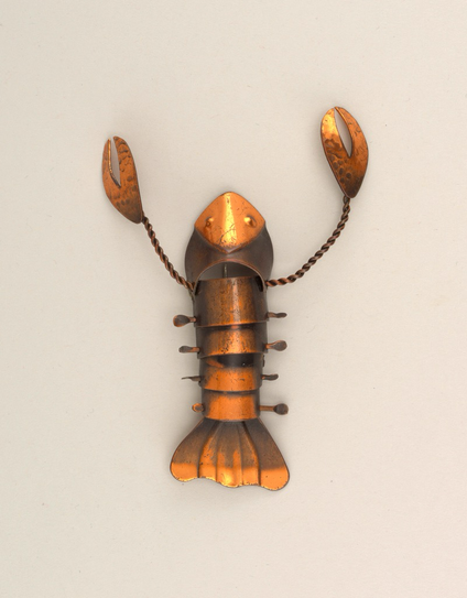 official museum photo, cooper brooch in the form of a lobster, top down profile on off-white background While living in a friend’s basement, Rebajes began transforming cans and scrap metal into animal shaped sculptures using the everyday tools his friend had lying around. In 1932, he displayed these works on an ironing board at the Washington Square Park Outdoor Festival and caught the eye of Juliana Force, the first director of the Whitney Museum of American Art, who purchased the entire collection for $30. Rebajes used the money to open his first shop in Greenwich Village—a four-foot wide space between two buildings with an improvised roof and a dirt floor. There he began developing what would become his emblematic line of copper jewelry, which was an accessibly priced collection inspired by cultural references, Modern art, and the natural world, as seen in this whimsical brooch in the shape of a lobster. Rebajes believed the greater public deserved to have well-designed and affordable objects, which is why everything he made sold for less than $10. His jewelry quickly gained popularity and in the late 1930s, his work was included in exhibitions at the Metropolitan Museum of Art, the Brooklyn Museum, and the 1939 New York World’s Fair.” via Cooper Hewitt FB
