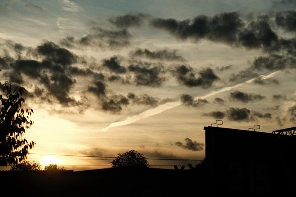 Contrail in the sky that ends at the bright light of raising the sun.
Looks similar to a common depiction of a nuclear missile hitting a land behind the horizon and exploding.