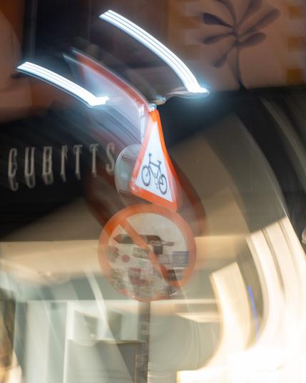 A cycle and no left turn sign, with two light trails either side