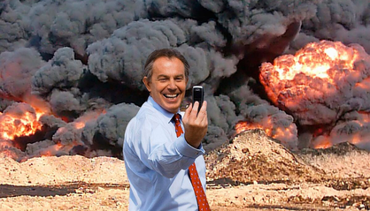 A digitally manipulated satirical image showing former UK Prime Minister Tony Blair in a light blue shirt and red tie, smiling broadly while holding up a mobile phone as if taking a selfie. He is positioned in the foreground. Behind him, a dramatic scene of massive explosions and thick black smoke dominates the background, evoking imagery of war and destruction. The stark contrast between Blair’s cheerful demeanour and the catastrophic background highlights the satirical and critical nature of the artwork, pointing to themes of political responsibility, conflict, and public image.

Participant: Tony Blair
Artists/Creators: Peter Kennard and Cat Phillipps