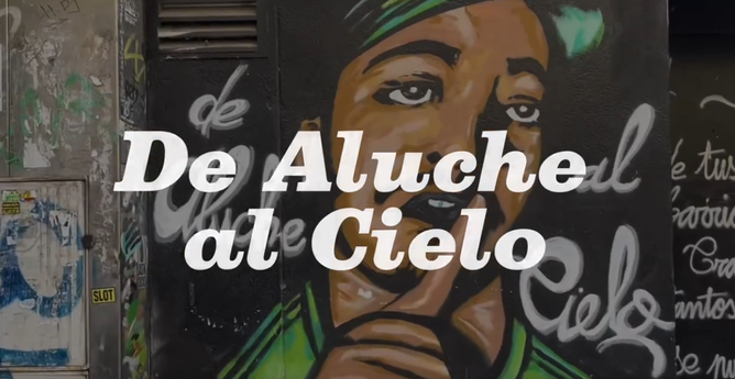 Imagen ilustrativa de la canción "De Aluche al Cielo" donde se ve ese texto escrito sobre un fondo de graffiti.