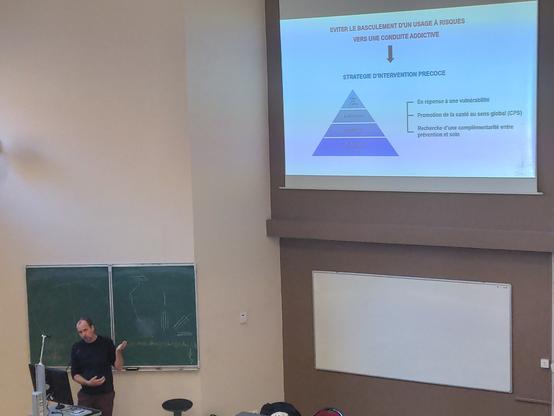 T. Birlouet, au pupitre présente la stratégie d'intervention précoce dans les addictions (diapo projetée)