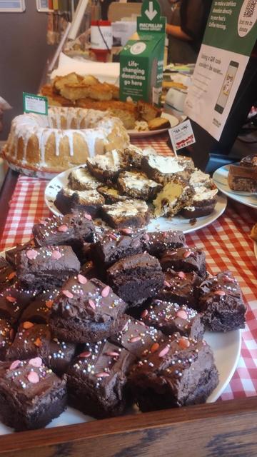 looking lengthwise along a table filled with plates of different cakes