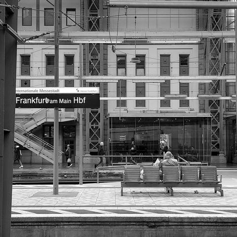 Scene in Frankfurt train station. Bench with person sitting.