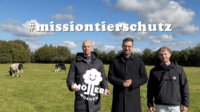Das Bild zeigt drei Männer auf einer grünen Wiese mit dem Logo von Möllers Morgen und dem Hashtag missiontierschutz. Im Hintergrund grasen Kühe auf der Weide. Die Szene wirkt engagiert und thematisiert den Einsatz für Tierschutz und nachhaltige Landwirtschaft.