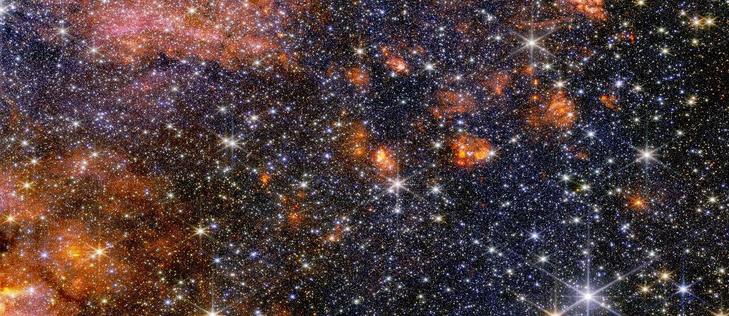 Stelle, gas e polvere cosmica nella nube molecolare Sagittarius B2 brillano nella luce del vicino infrarosso, catturata dalla NIRCam (Near-Infrared Camera) di Webb. In questa luce, gli astronomi possono osservare meglio le stelle diverse e colorate della regione, ma meno la struttura del gas e della polvere. Gli strumenti di Webb forniscono ciascuno agli astronomi informazioni importanti che aiutano a costruire un quadro più completo di ciò che avviene in questa affascinante porzione del centro della nostra galassia.