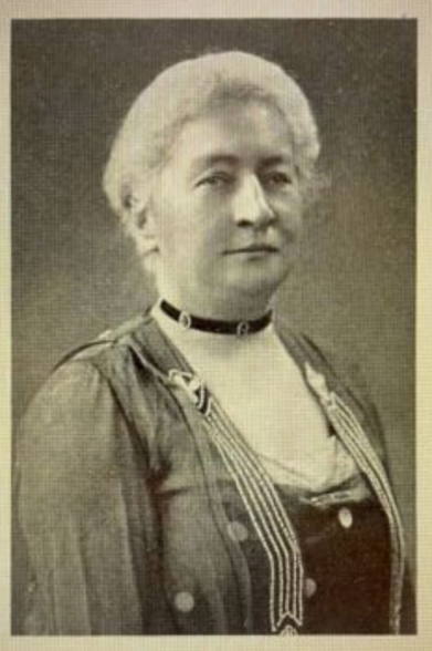 Louise Hortense Snowden in the 1920s; a white woman with white hair, wearing a loose-fitting jacket over a dark dress, and a distinctive black choker