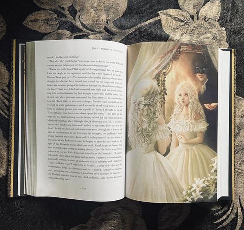 A book page spread: the left page is text and the right side is an illustration of Christine being lured into the mirror by the Phantom.