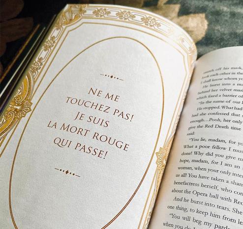 A quote from the book that says in French, “Ne me touchez pas! Je suis la Mort Rouge qui passe!” There is a decorative gold border around the quote.
