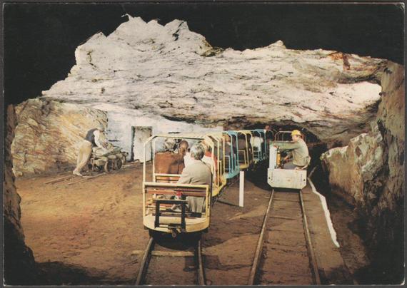 Printed colour postcard showing a view of visitors on the minirail at the Ceudwll Llechwedd Slate Caverns at Blaenau Ffestiniog in Merionethshire.

Published by J. Arthur Dixon, No L6/SP. 3481, c.1970.

Postally unused.

Good condition, with slight corner bumps.
