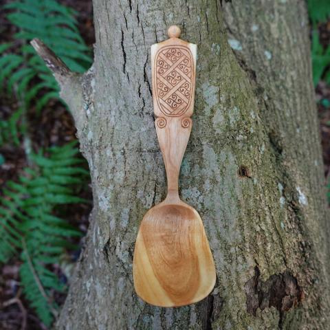 Wooden spoon laying on a tree log