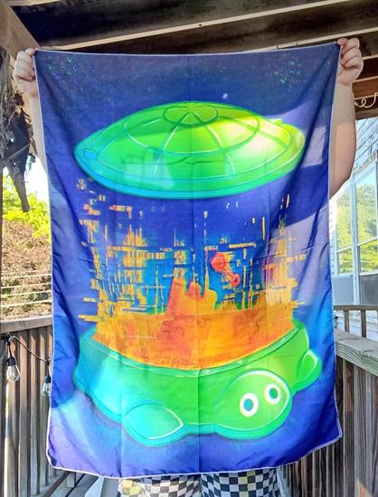Man holding a turtle Sandbox tapestry outside on a porch