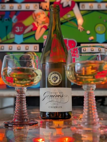 bottle of chablis with two filled glasses on a 1970's pinball machine