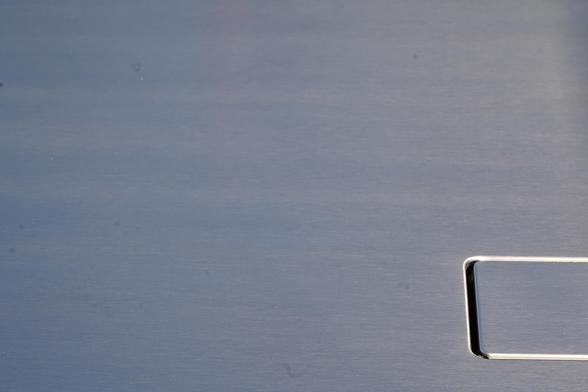 Photo: brushed aluminium DeLoran bonnet with detail of square panel in bottom right hand corner