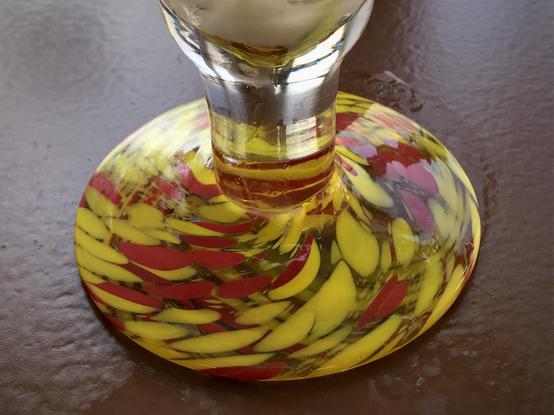 Fuß eines Eisbechers mit Farbflecken in gelb und rot.