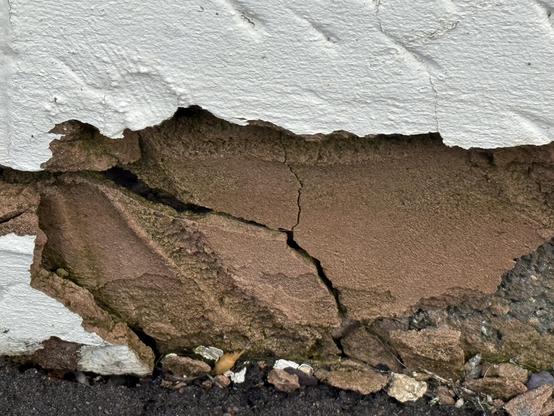 Close up of a damaged external wall render. Damaged by water from a broken gutter above.