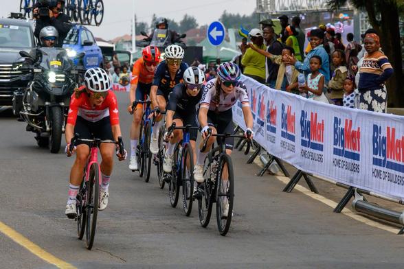 Women cyclists competing in the UCI Women’s Elite Road Race at the World Championships in Kigali, with spectators cheering from the roadside.